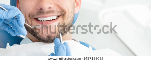Young man at the dentist.\
Dental care, taking care of teeth. Picture with copy space for\
background.