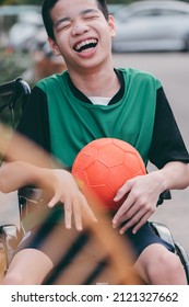 A young man with disability fun face with playing a ball on the outdoor with family, Sport and relaxing or exercise for the disabilities person concept.