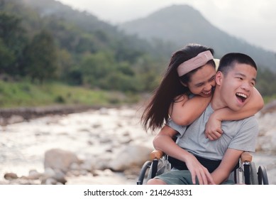 Young Man With A Disability And Parent With Smiley Face On Nature Background, Relaxing, Playing, Learning And Exercise In The Outdoor On Vacation With Family,Natural Therapy And Mental Health Concept.