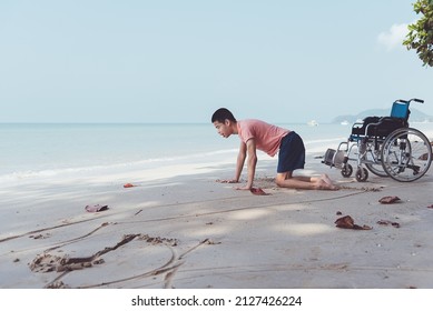 Young Man With Disability Relax And Practice Small Muscle Skills Through Sand Play And Large Muscles Skills Through Crawling On The Beach In Summer, Outdoor Natural Therapy And Mental Health Concept.