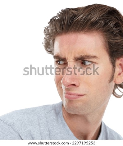 Young man, disgust and face looking over shoulder with anger, confused or frown against a white studio background. Isolated male model with annoyed, angry or funny facial expression and smirk