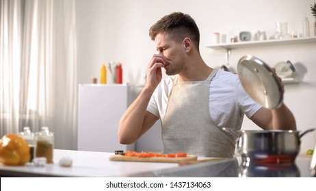 Young Man Disgusted With Stinky Meal On Stove, Spoiled Ingredients, Untasty Food