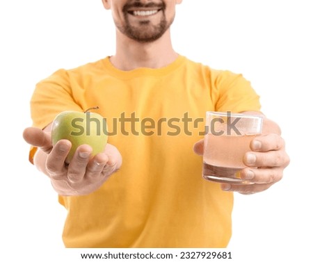 Young man with dissolved tablet in glass of water and apple on white background, closeup