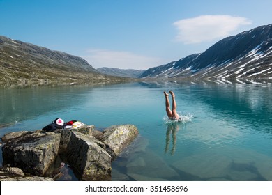 Young man dives into a cold blue mountain lake, Norway - Powered by Shutterstock