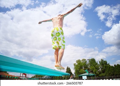 Young Man Diving Off A Diving Board