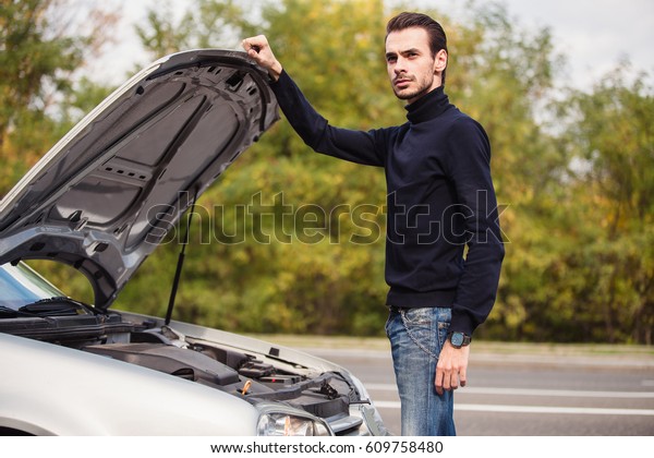 The young man does not\
know what went wrong in his car. He is on the road and does not\
know what to do 