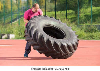 Young man does strongman exercise - Powered by Shutterstock