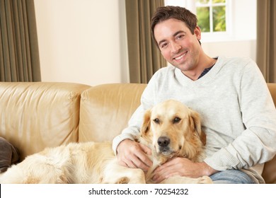 Young Man With Dog Sitting On Sofa