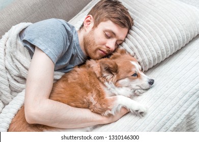 young man and a dog are sleeping in a bed. Closeup portrait. Concept rest