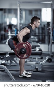 Young Man Doing Barbell Row In The Gym