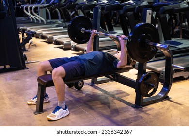 Young man doing bench press. Young man working out at the gym, chest day. - Powered by Shutterstock