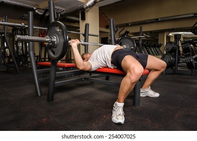 Young Man Doing Bench Press Workout In Gym