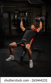 Young Man Doing Bench Press Workout In Gym