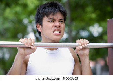 Young Man Doing Chin-ups, Clenching Teeth