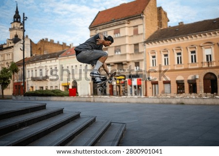 Young man doing a dynamic ollie during a skateboarding session in trg slobode, novi sad, showing urban sports lifestyle and skill