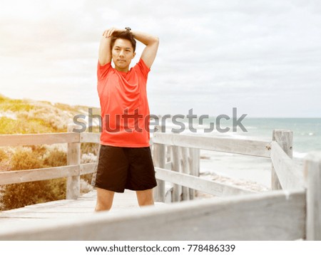 Young man doing exercise at the beach