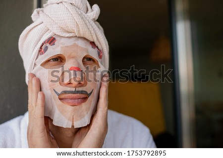 Young Man Doing Facial Mask Sheet. Beauty And Skin Care Concept