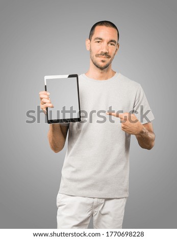Young man doing gestures using a tablet