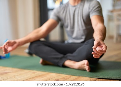 Young man doing gyan mudra symbol and meditating at home - Powered by Shutterstock