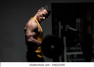 Young Man Doing Heavy Weight Exercise For Biceps