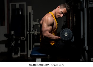 Young Man Doing Heavy Weight Exercise For Biceps