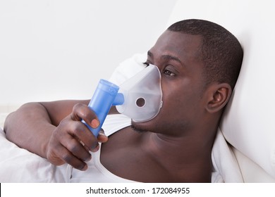 Young Man Doing Inhalation Through Oxygen Mask