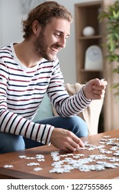 Young Man Doing Jigsaw Puzzle At Home