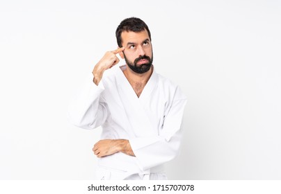 Young man doing karate over isolated white background making the gesture of madness putting finger on the head