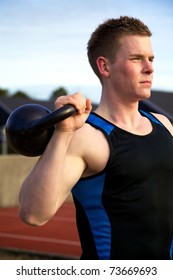 Young Man Doing Kettlebell Workout Outside