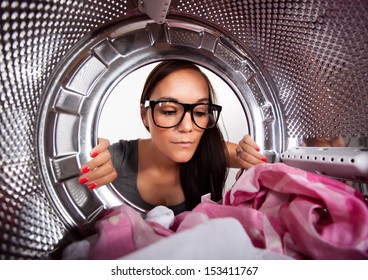 Young Man Doing Laundry View From The Inside Of Washing Machine. 