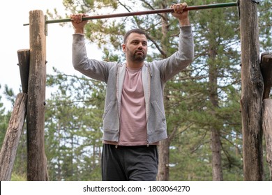 Young Man Doing Pull Ups In Out Door Gym. 