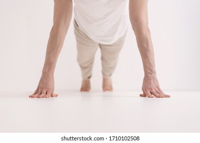 Young man doing Push ups with fingers,, working out, indoor, white interior, living room floor. Close-up of hands.