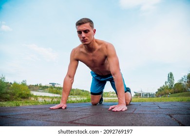 Young man doing pushups in city park area - Training and exercising for endurance - Fitness healthy lifestyle concept outdoor