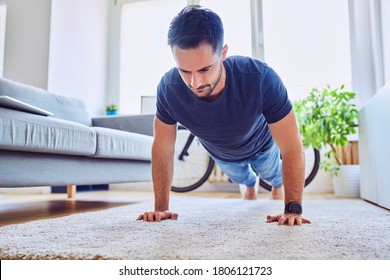 Young Man Doing Pushups At Home During Break From Freelance Work