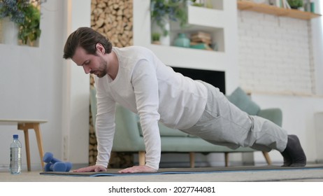 Young Man Doing Pushups On Excercise Mat At Home