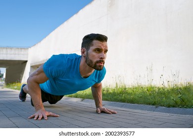 Young man doing pushups outdoors
