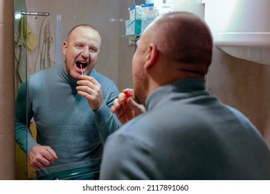 Young Man Doing Self Test For COVID-19 At Home With Antigen Test Kit. Coronavirus Mouth Swab Test For Infection. Young Man Holds A Swab Into His Mouth For COVID-19 Home Test.