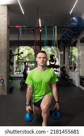 A Young Man Doing Split Squat, And Holding The Kettlebells