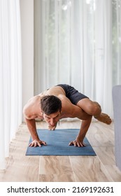 Young Man Doing Strength Pilates Or Yoga Workout In The Morning. Muscular Man Practicing Sweat Yoga At Home