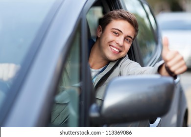 Young man doing thumps-up in car