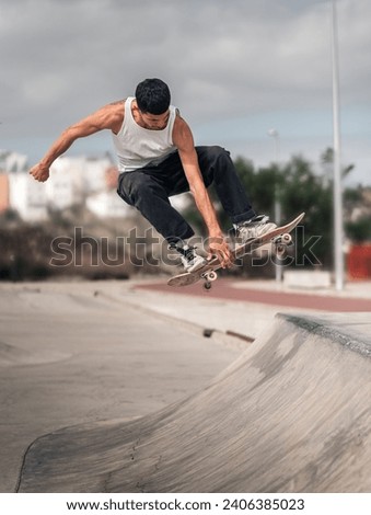 young man doing a trick called boneless in a ramp of a skate park. movement 3
