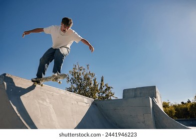 A young man doing tricks on his skateboard at the skate park. Active sport concept - Powered by Shutterstock