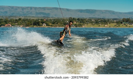 young man doing wakeboarding in a lake whit mountains - Powered by Shutterstock