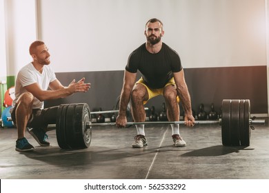 Young Man Doing Workout With A Personal Trainer.