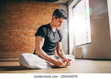 Young Man Doing Yoga In Big Bright Training Gym