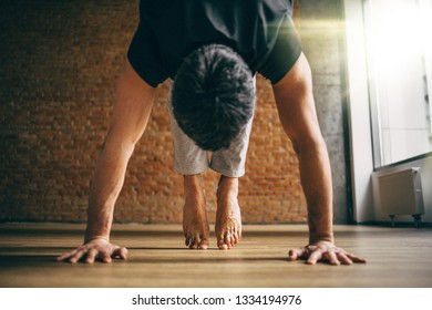 Young Man Doing Yoga In Big Bright Training Gym