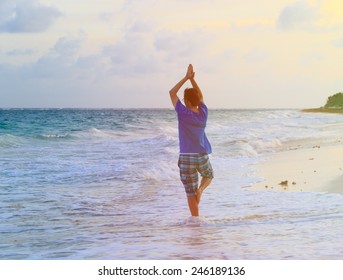 young man doing yoga at summer sunset beach - Shutterstock ID 246189136
