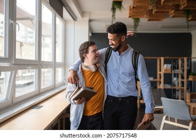 Young man with Down syndrome and his tutor with arms around looking at each other indoors at school - Powered by Shutterstock