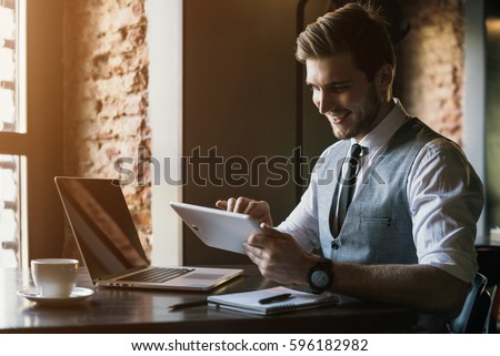 Young man drawing template for the web site associated with digital marketing, current trends and tendencies of UX / UI design. Businessman who rules his company remotely, like a freelancer