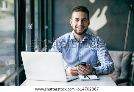 Young man drawing template for the web site associated with digital marketing, current trends and tendencies of UX / UI design. Businessman who rules his company remotely, like a freelancer